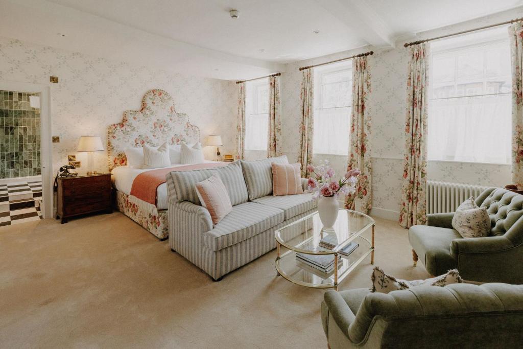 a bedroom with a bed and a couch and chairs at The William Cecil in Stamford
