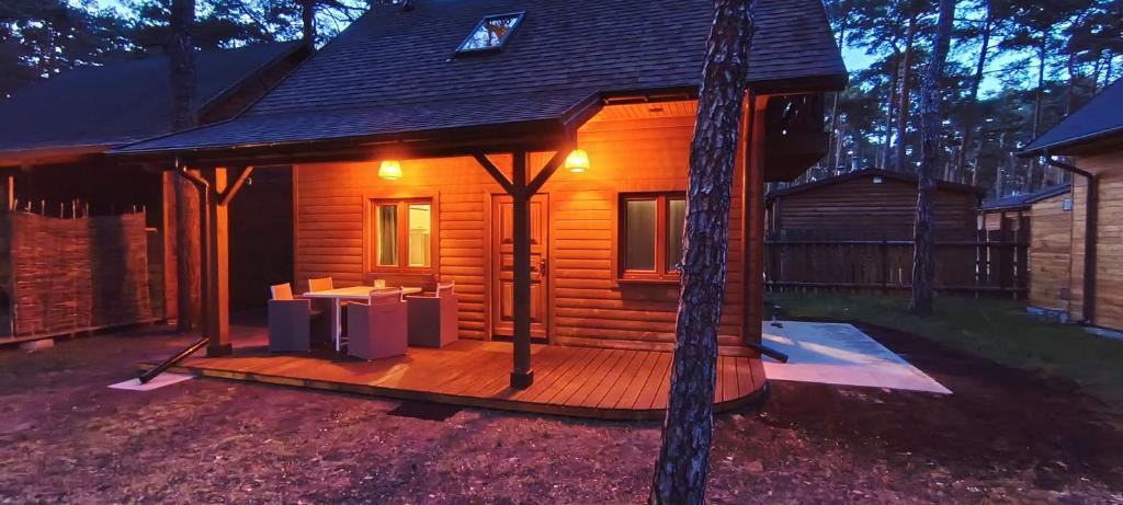 a log cabin with a deck in the yard at Domek w Sielpi in Sielpia Wielka