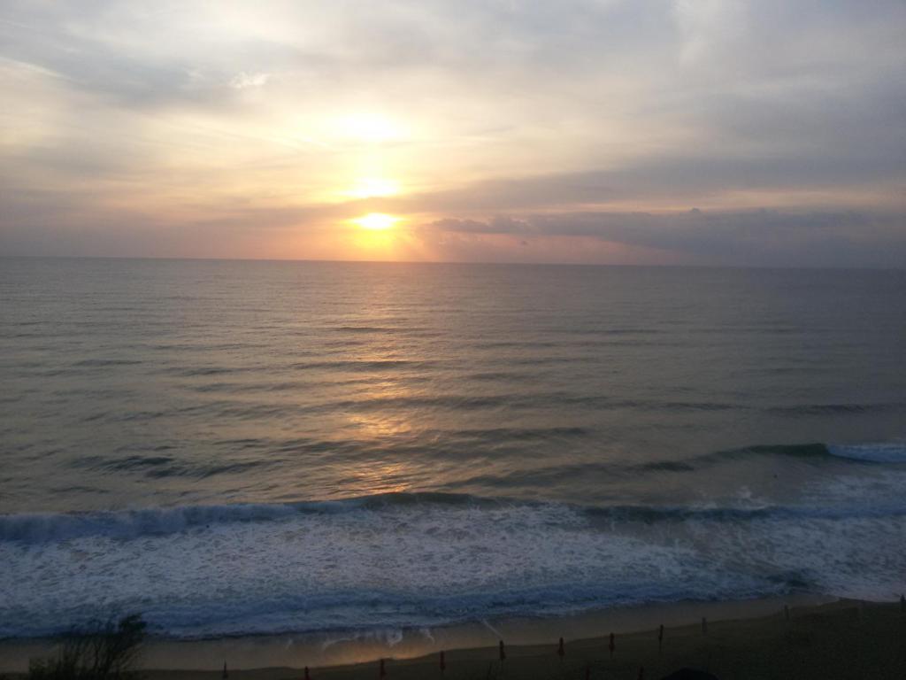 a sunset over the ocean with the sun setting at Byala Vista Cliff Apartments in Byala