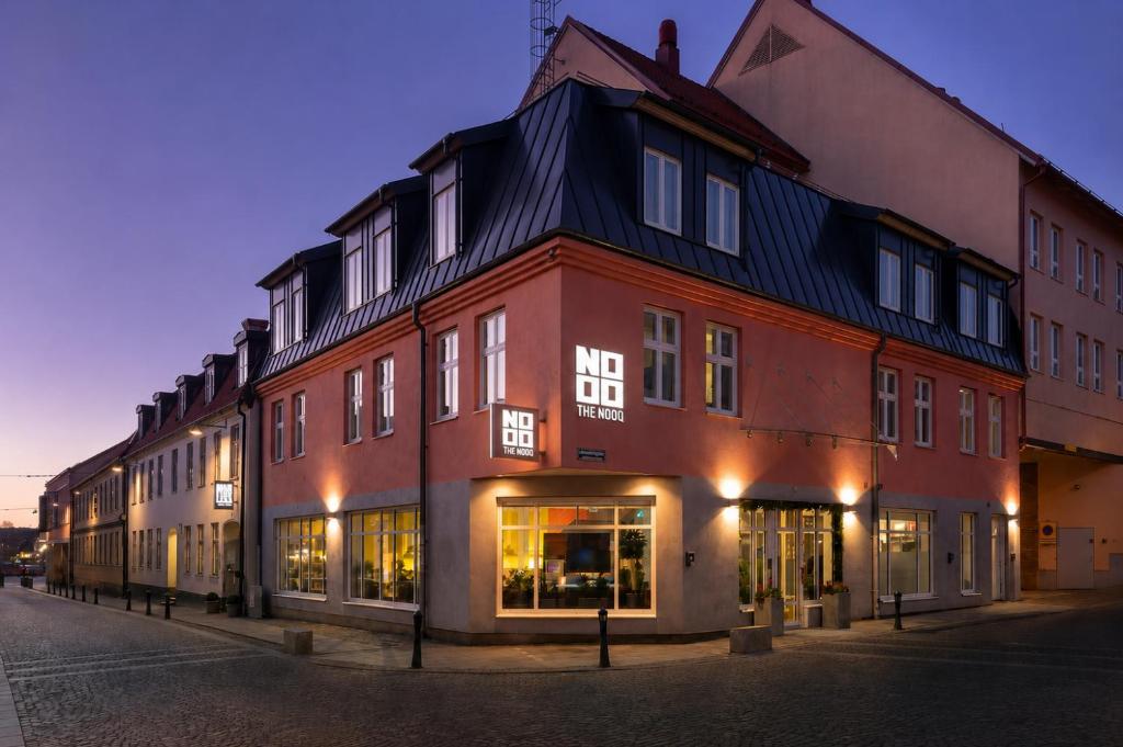ein großes rotes Gebäude an einer Straßenseite in der Unterkunft The Nooq Lund - Hotel & Studios in Lund