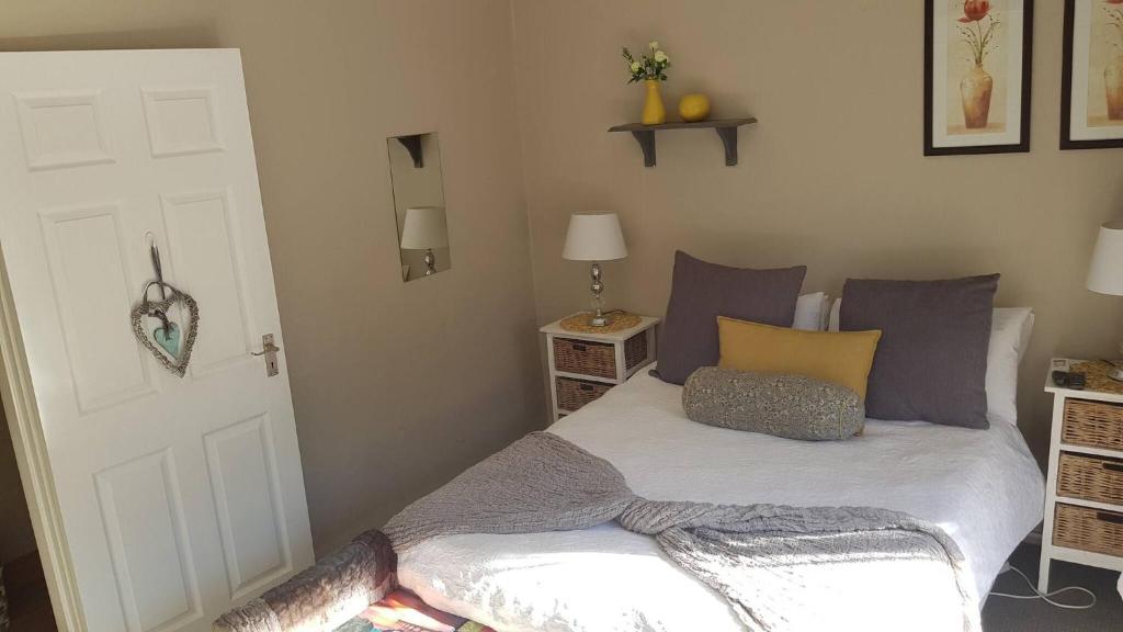 a bedroom with a bed with purple and yellow pillows at Junior Suite with Pool View - in Port Elizabeth