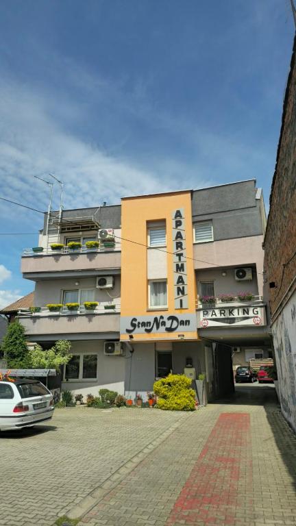 a building with a sign on the front of it at Apartmani Stan Na Dan in Šabac