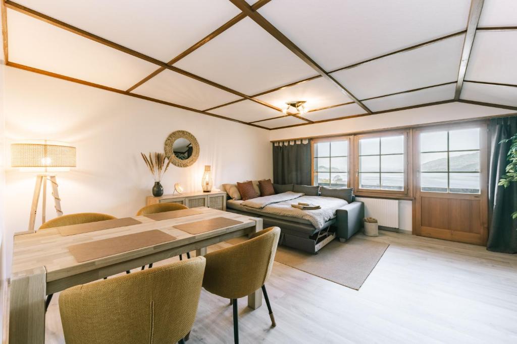 a living room with a couch and a table at Thimo's Lakeview - Sunset near Interlaken in Leissigen