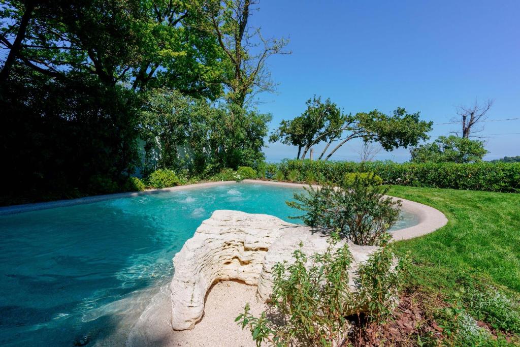 a swimming pool in the middle of a yard at Le Relais du Lierre - Conero Nature Retreat in Poggio