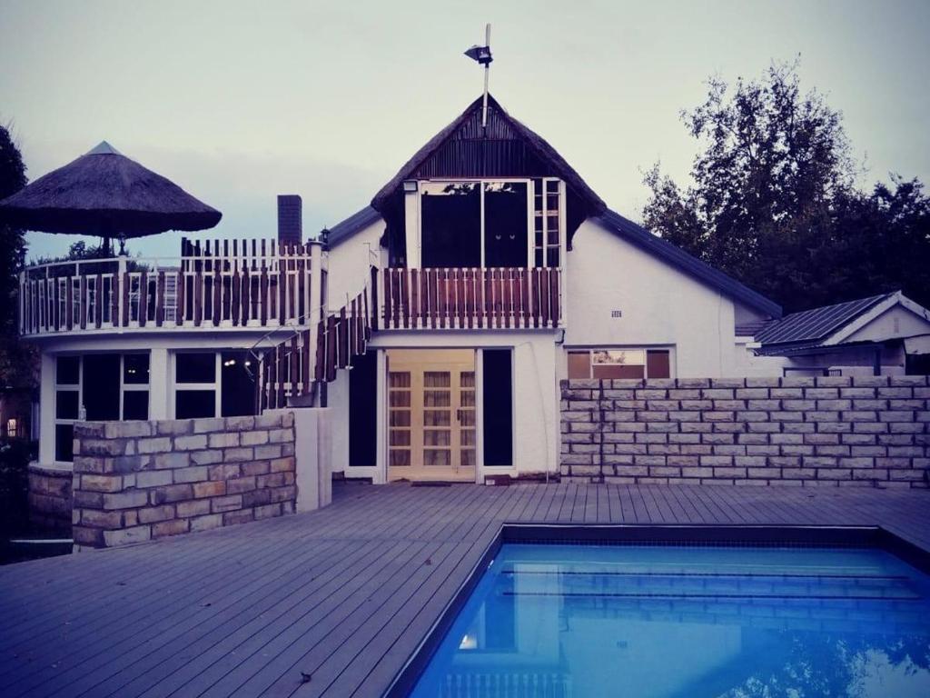 a house with a swimming pool in front of a building at Bella - Rosa in Ficksburg