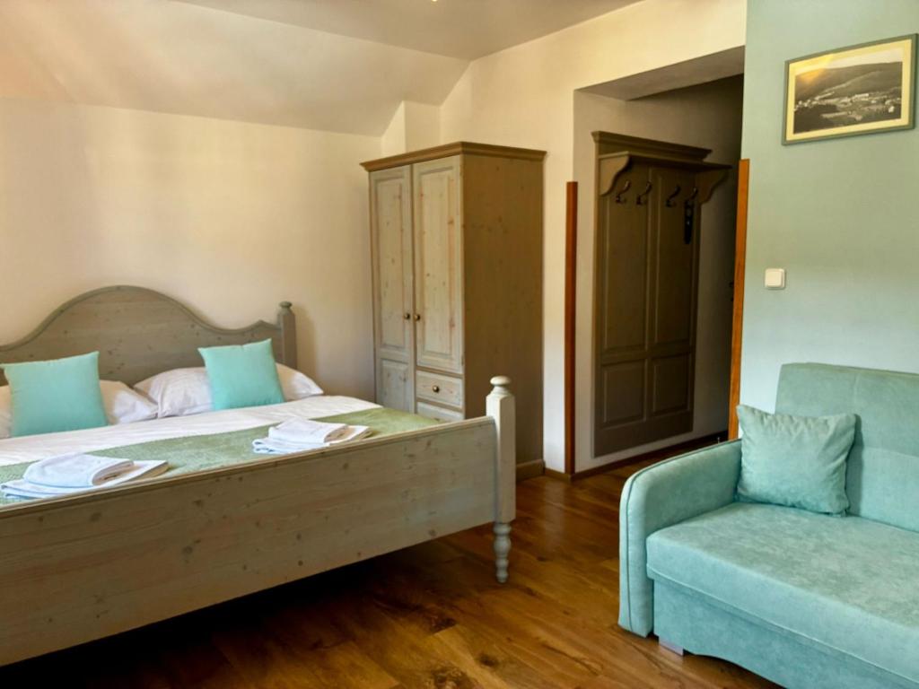 a bedroom with a bed and a blue chair at Grand Apartments Špindlerův Mlýn in Špindlerův Mlýn