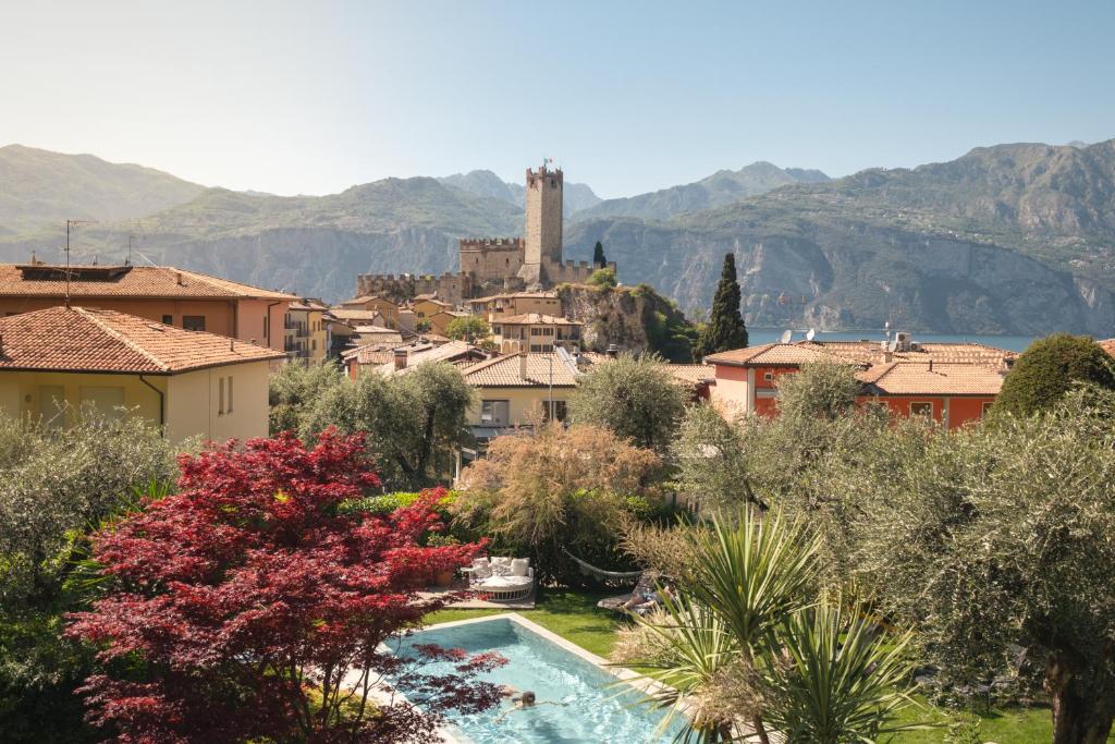 a view of a town with a swimming pool and mountains at Eco Hotel Ariston in Malcesine