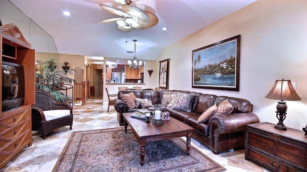 a living room with a brown leather couch and a table at 403 Mariners Club in Key Largo