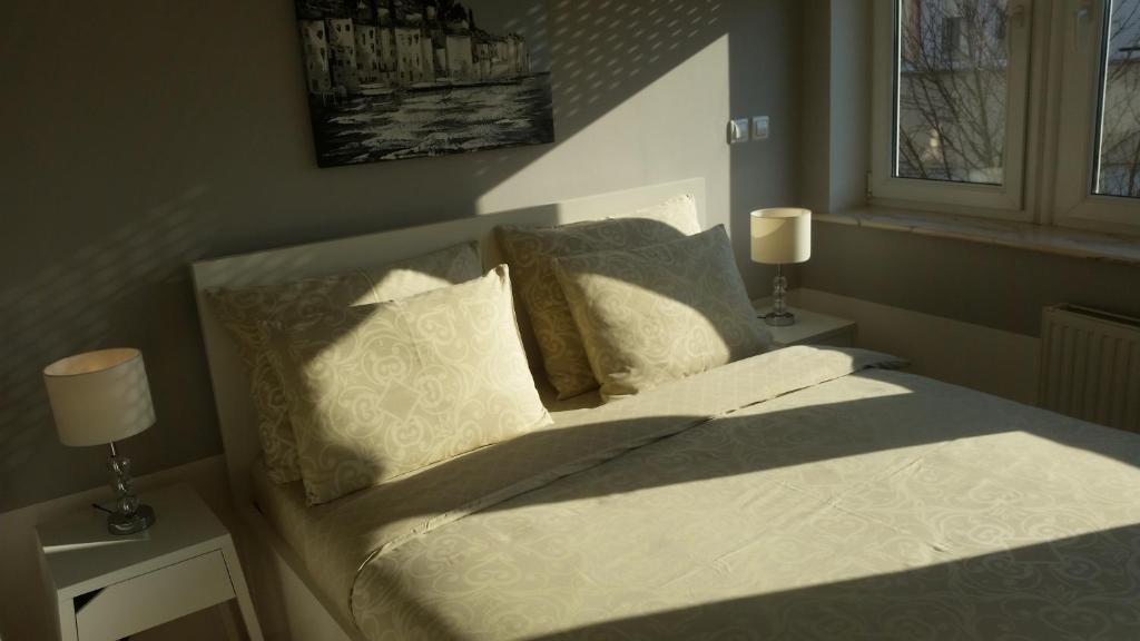 a bedroom with a bed with two tables and two lamps at Apartments 4 Karla in Zagreb