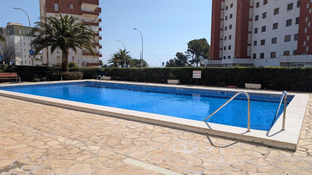 a large swimming pool in a city with buildings at Apartamento Mar y Encanto in Miami Platja