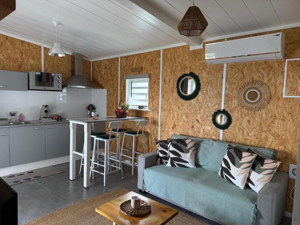 a living room with a couch and a kitchen at Lebon Coin Tranquille in Le Tampon