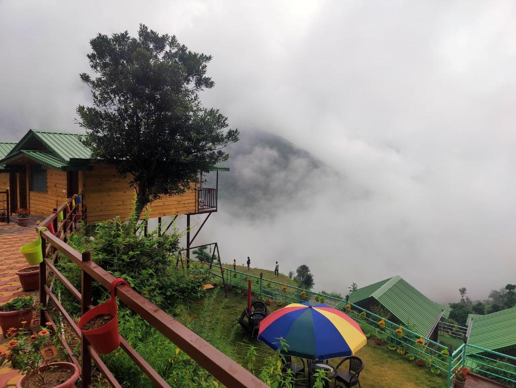 a colorful umbrella sitting next to a house at LaSerene The Cottage - Pangot in Nainital