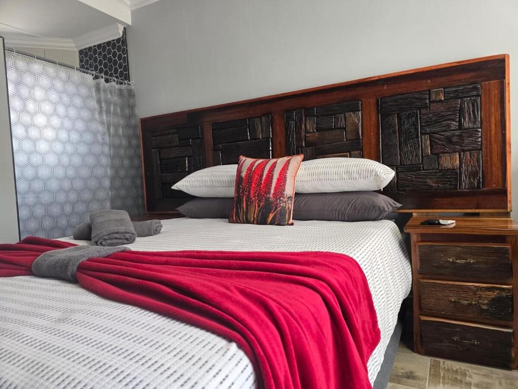 a bedroom with two beds with a red blanket at De Oude Sleeper Inn 2 Apartment in Kimberley
