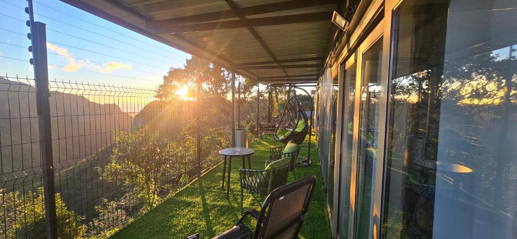 a balcony with a table and a view of the sun at Green Discovery's Birds' Nests in Henrietta