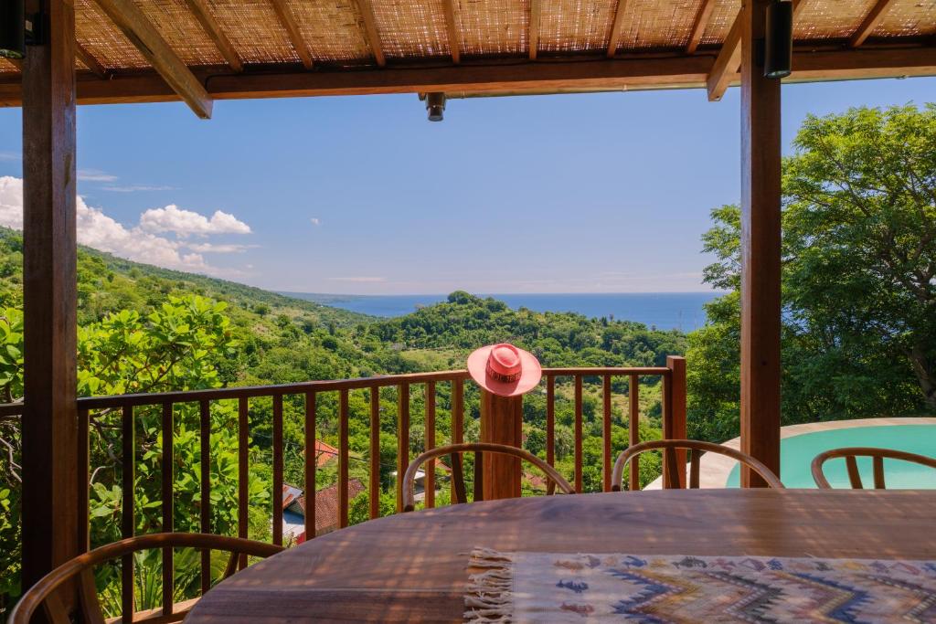 a table on a balcony with a view of the ocean at Villa Layan Hillside Residency with views and infinity pool in Amed in Ambat