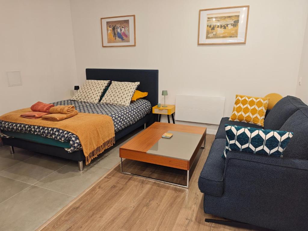 a living room with a bed and a couch at La Maison de violette meublé classé 3 étoiles in Montdidier