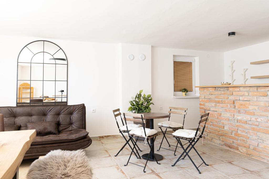 a living room with a couch and a table and chairs at Apartmán Marie in Mutěnice