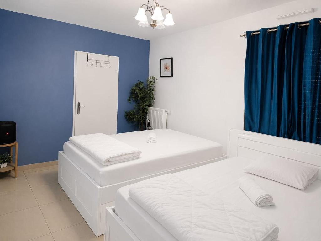 a bedroom with two beds and a blue wall at Noisiel appartement 2piece in Noisiel