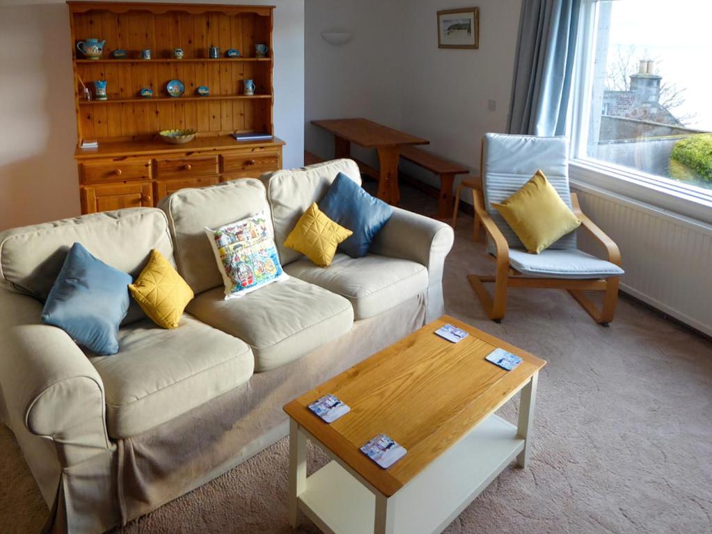 a living room with a couch and two chairs and a table at Crail House in Crail