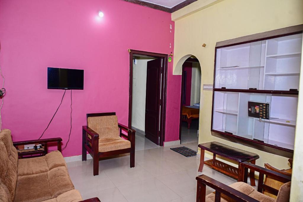 a living room with a pink wall at Coorg villa homestay in Madikeri