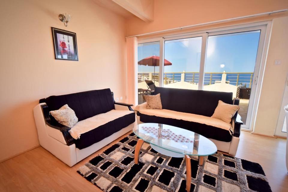 a living room with two couches and a glass table at Penthouse S in Bar