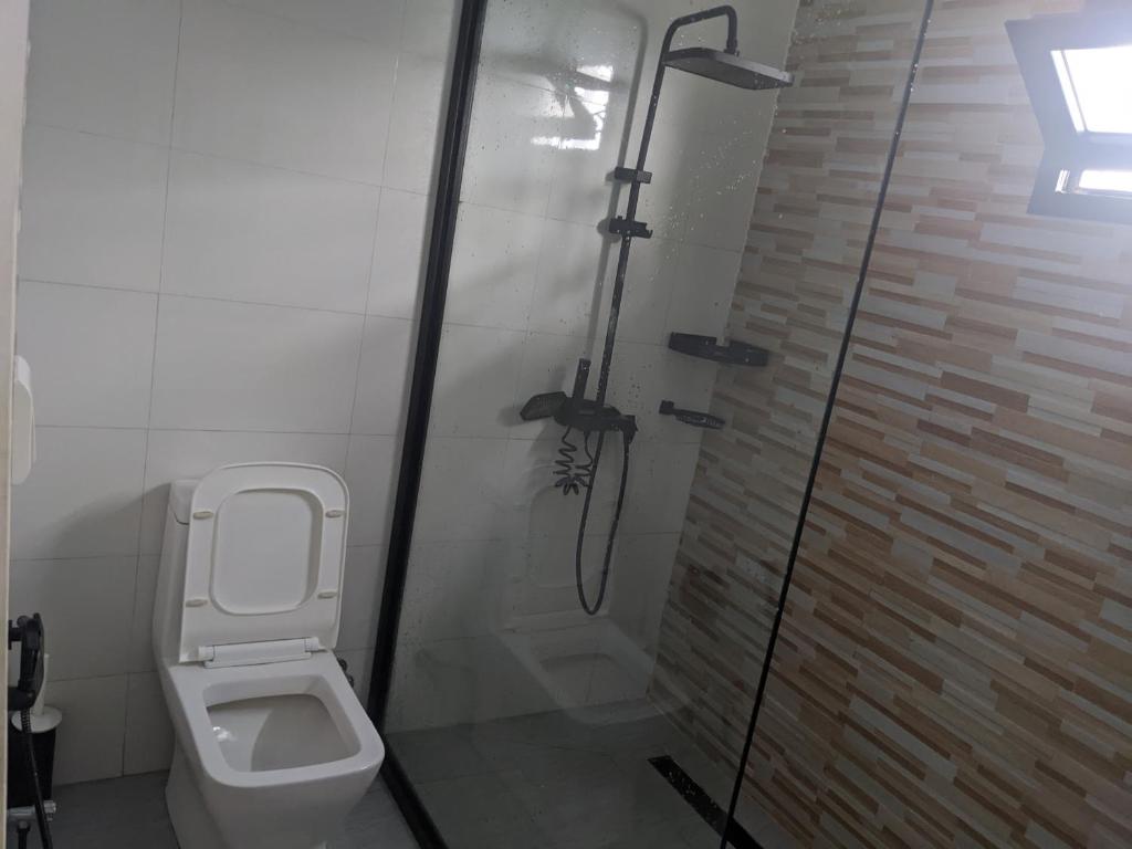 a bathroom with a toilet and a glass shower at Ambourvi in Mahajanga