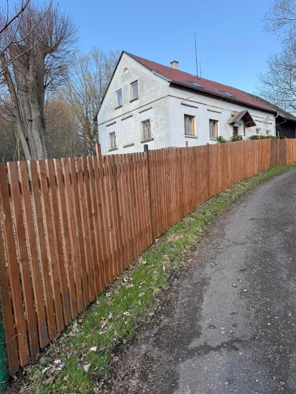 a wooden fence in front of a white house at Chalupa V soukromí - Chřibská in Chřibská