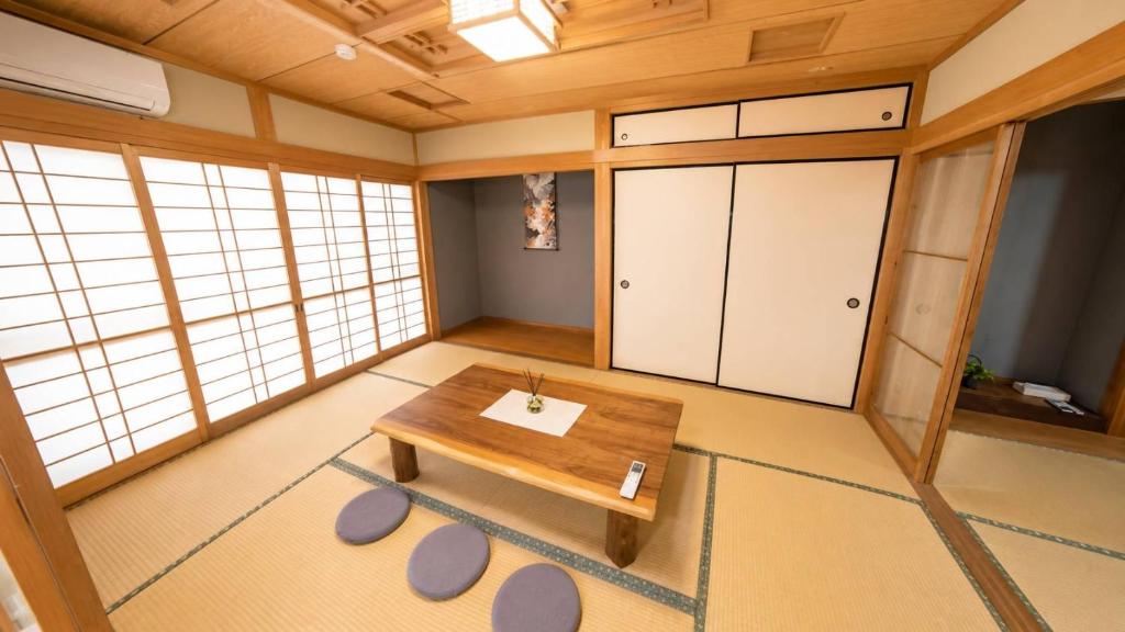 a room with a wooden table in a room at 姫路駅から徒歩4分 最大13名に貸し切り一軒家 先姫亭 in Himeji