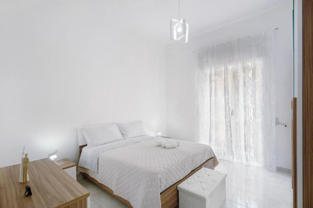 a white bedroom with a bed and a window at Angel's House in Sarno