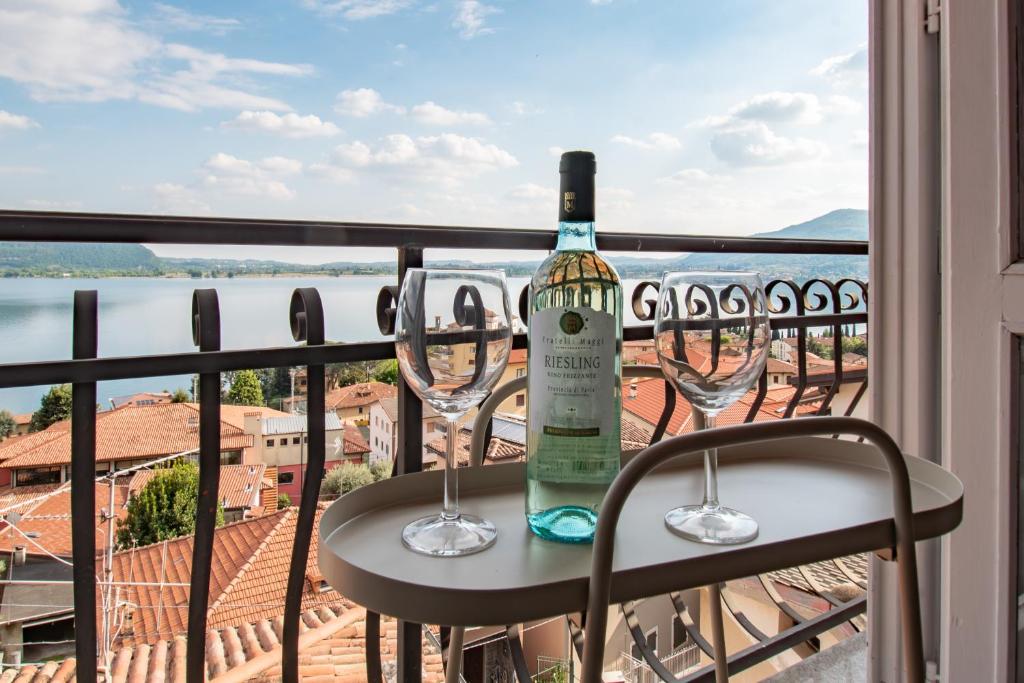 a bottle of wine sitting on a table with two wine glasses at Casa di Emilia Iseo in Predore