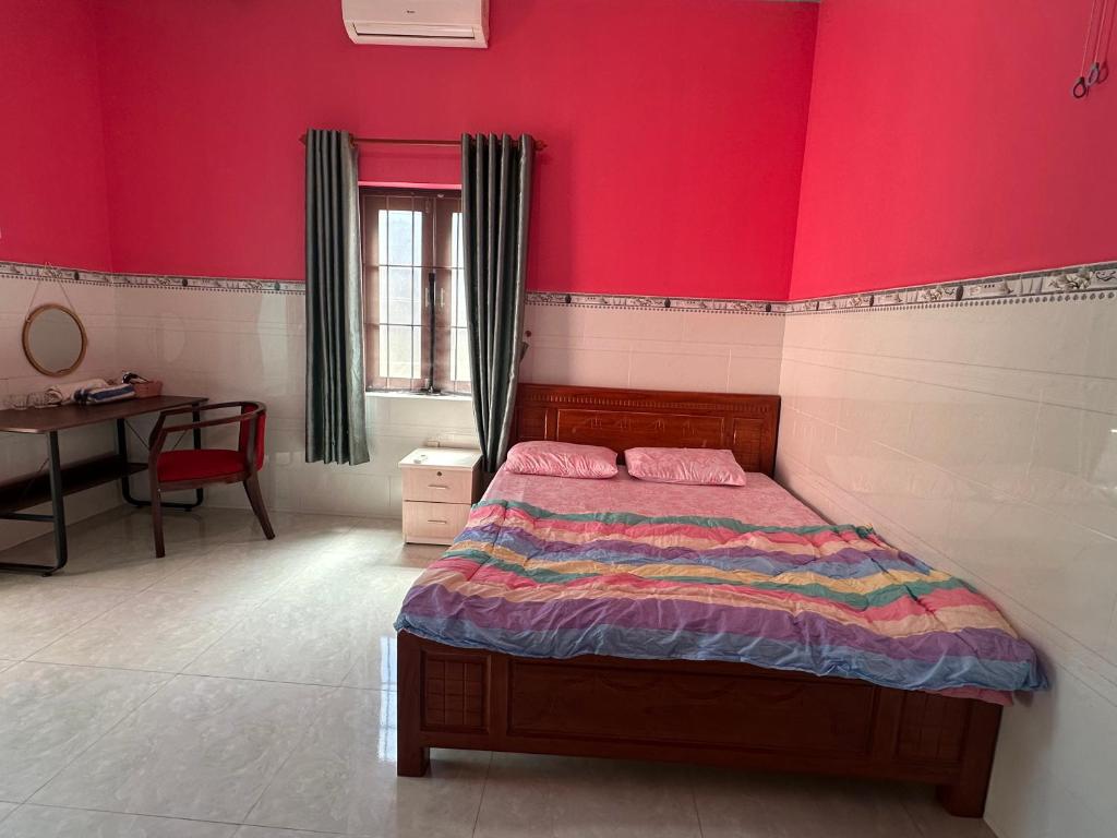 a bedroom with a bed and a red wall at Song Anh Mui Ne Guesthouse in Mui Ne