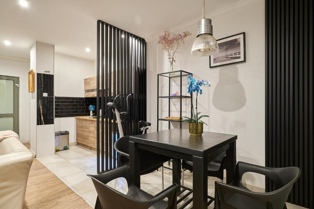 a dining room with a black table and chairs at Apartament Gold 3 in Złotoryja