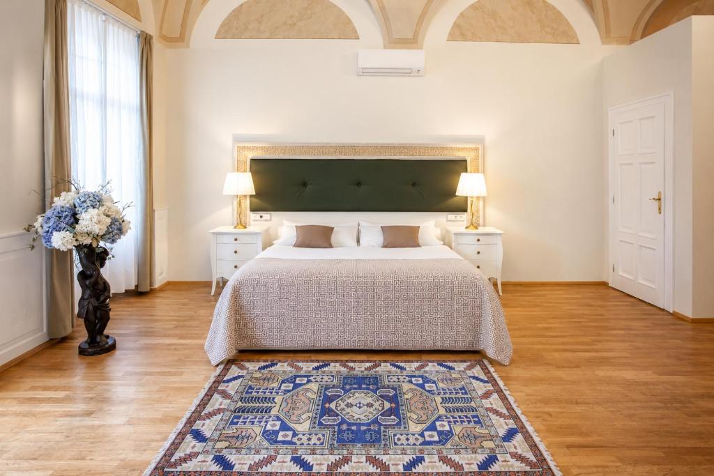 a bedroom with a large bed and a rug at Little King Hotel U Malvaze in Prague