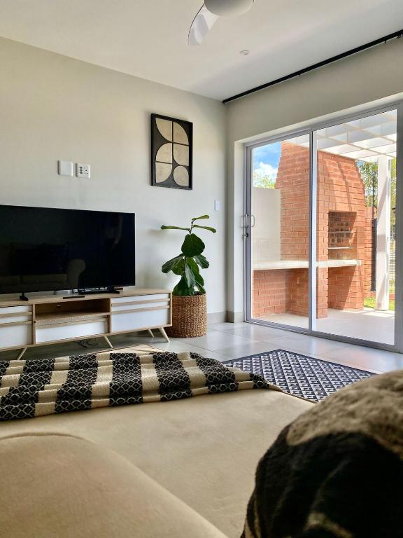 a living room with a flat screen tv and a couch at SixtyOneAt1- George Central in George