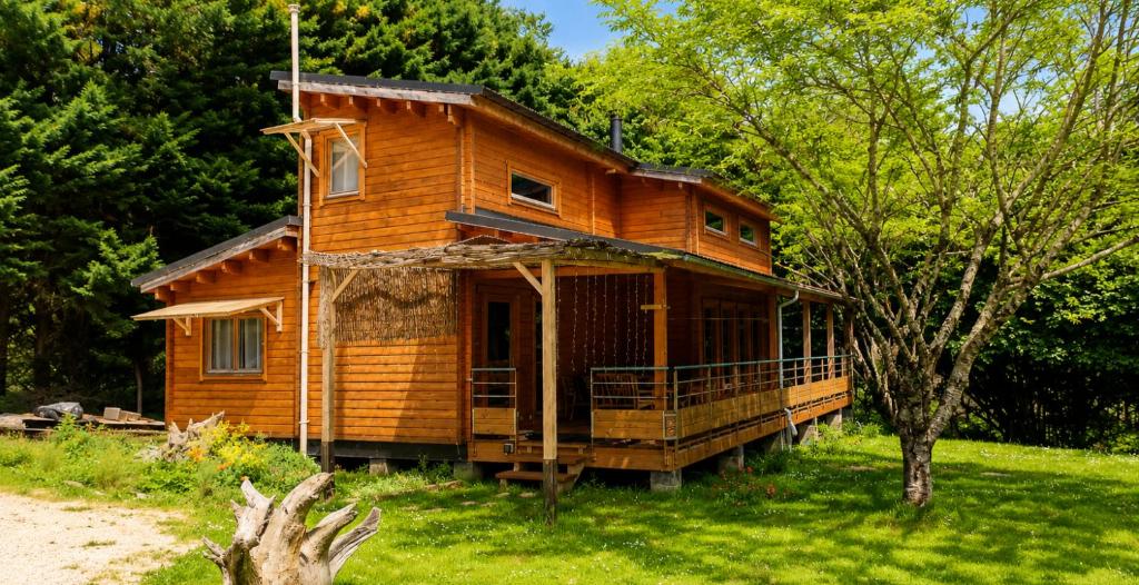 a wooden house in the middle of a yard at Le chalet Péi Cosy & Nature proche de Périgueux in Marsaneix