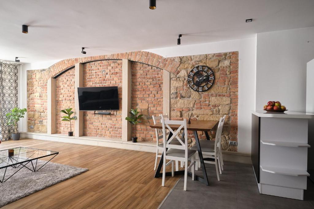 a living room with a brick wall and a table and chairs at Apartament Gold 2 in Złotoryja