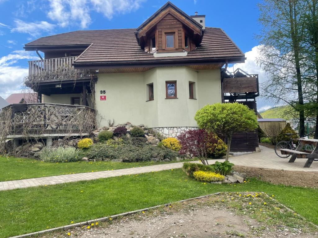 a house with a gambrel roof and a yard at Agroturystyka Świt dobry in Strzebowiska