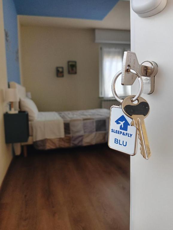a door with a keychain in a room with a bed at Sleep & Fly Villa Ornella in Case Nuove