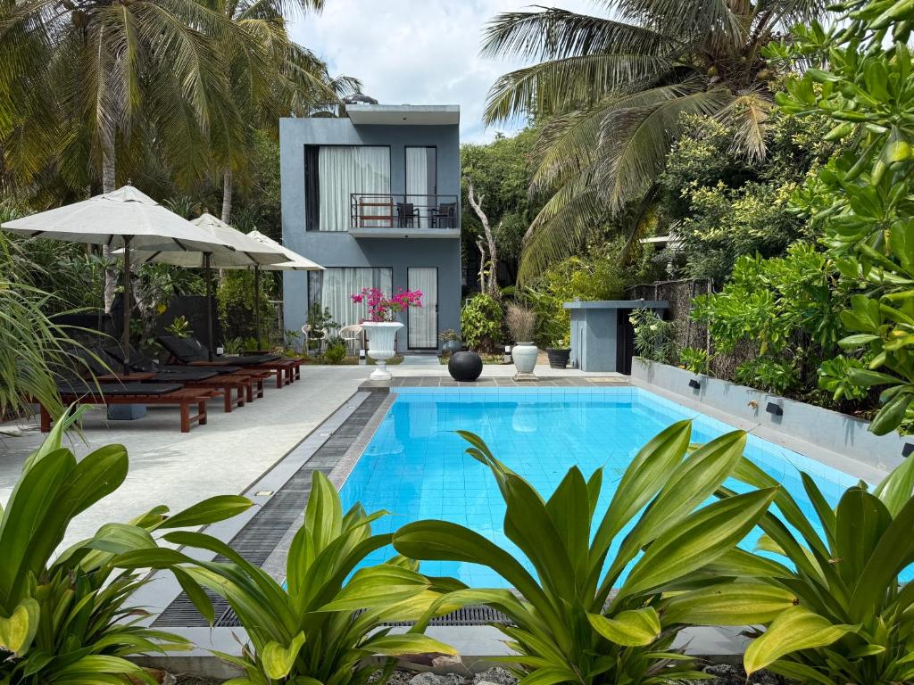 a swimming pool in front of a villa at Endlessblue Resort Kalametiya in Kalametiya