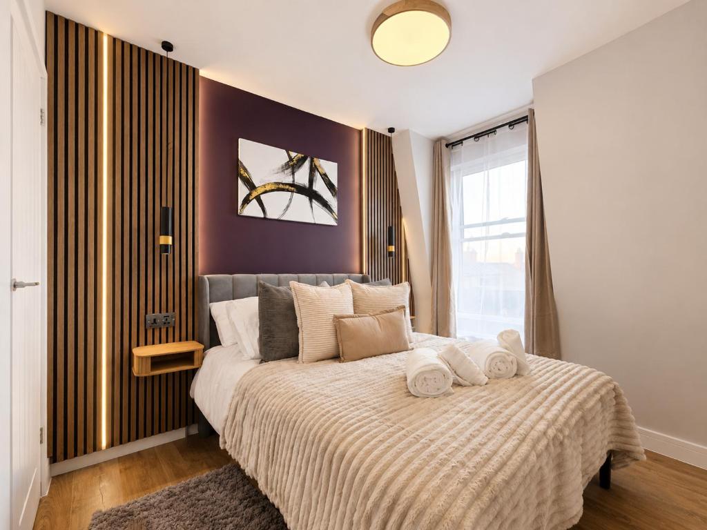 a bedroom with a large bed with towels on it at Flat 7 in central Bromley - underground parking in Bromley