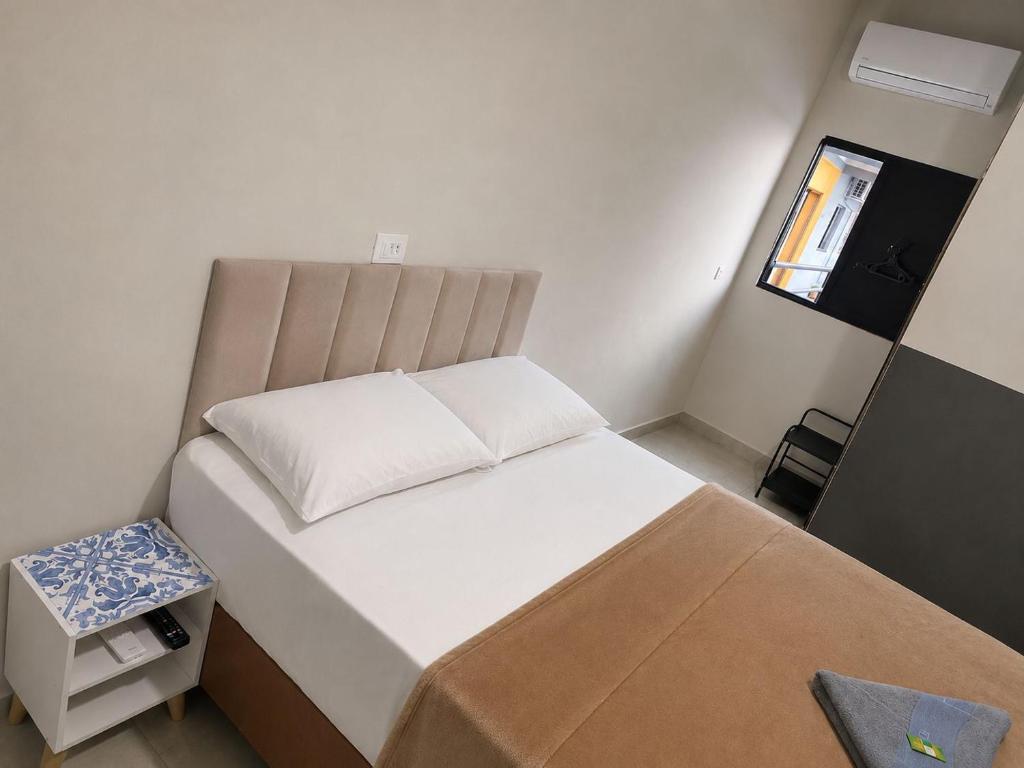a small bedroom with a bed and a small table at Hotel Catedral in Ribas do Rio Pardo