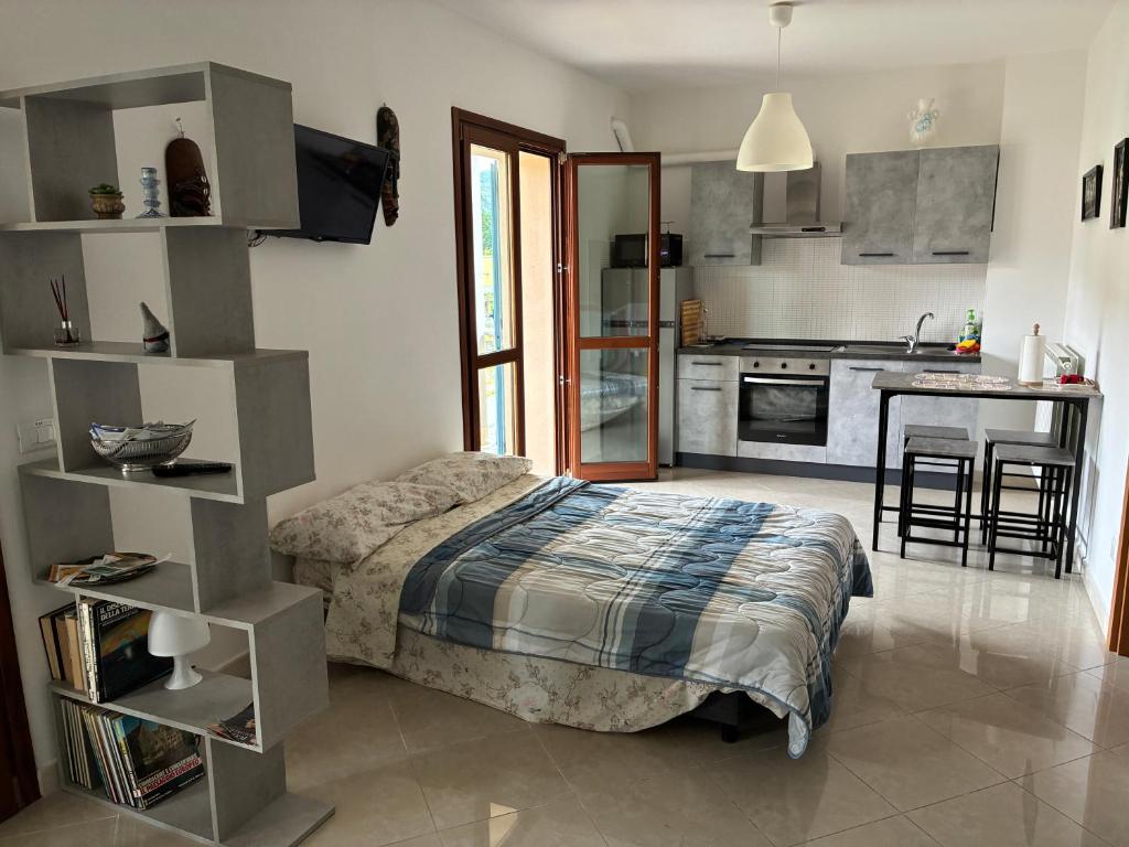 a bedroom with a bed and a kitchen at Le Persiane Azzurre est in Albiano
