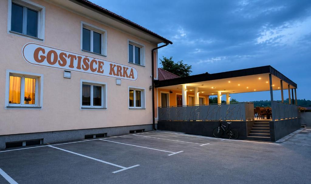 a building with a parking lot in front of it at Gostišče Krka in Znojile pri Krki