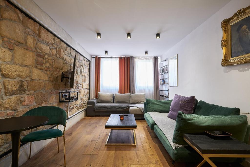 a living room with a green couch and a brick wall at Apartament Gold in Złotoryja