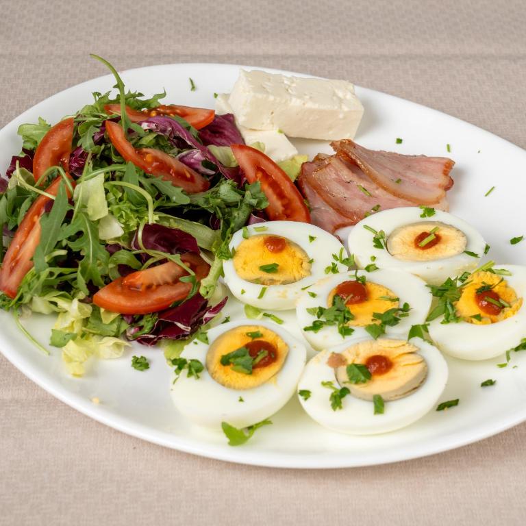 a plate of food with eggs and a salad at Barrique 30 - Breakfast Delivered & Minibar - Free parking - Mall Area in Braşov