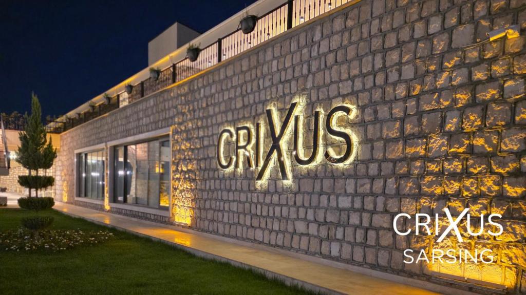 a building with a sign on the side of it at Crixus Hotels Sarsing in Sarsing
