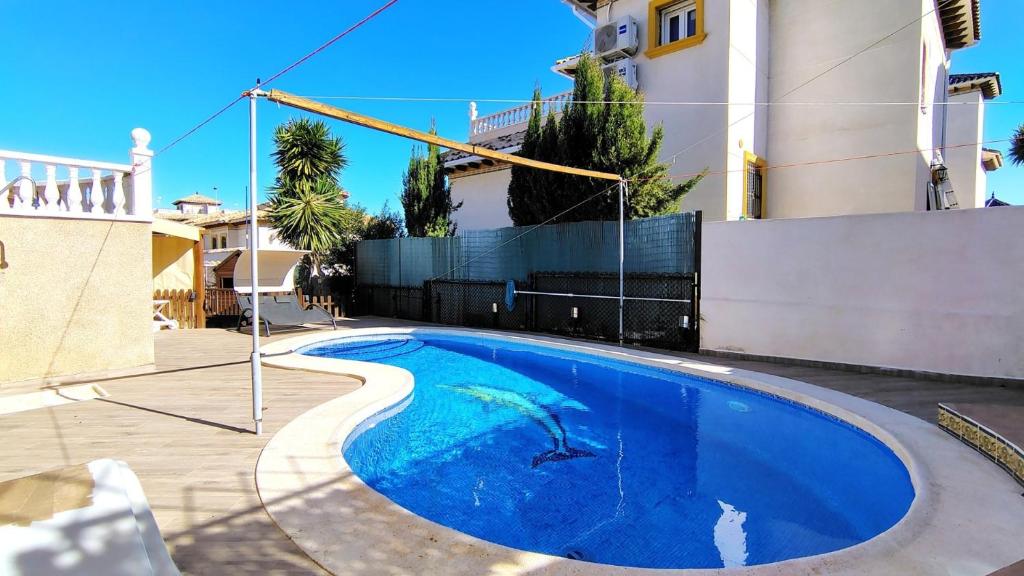 a blue swimming pool in the middle of a house at Planta baja con piscina privada in Playas de Orihuela