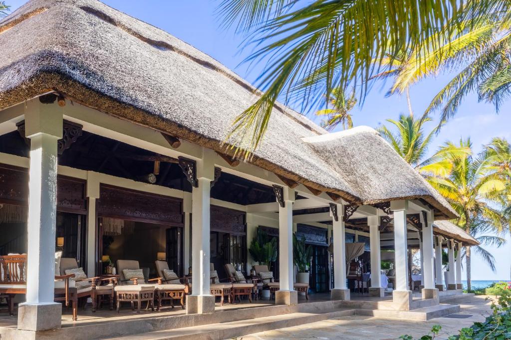 a restaurant on the beach with a thatched roof at The Palms Zanzibar in Bwejuu