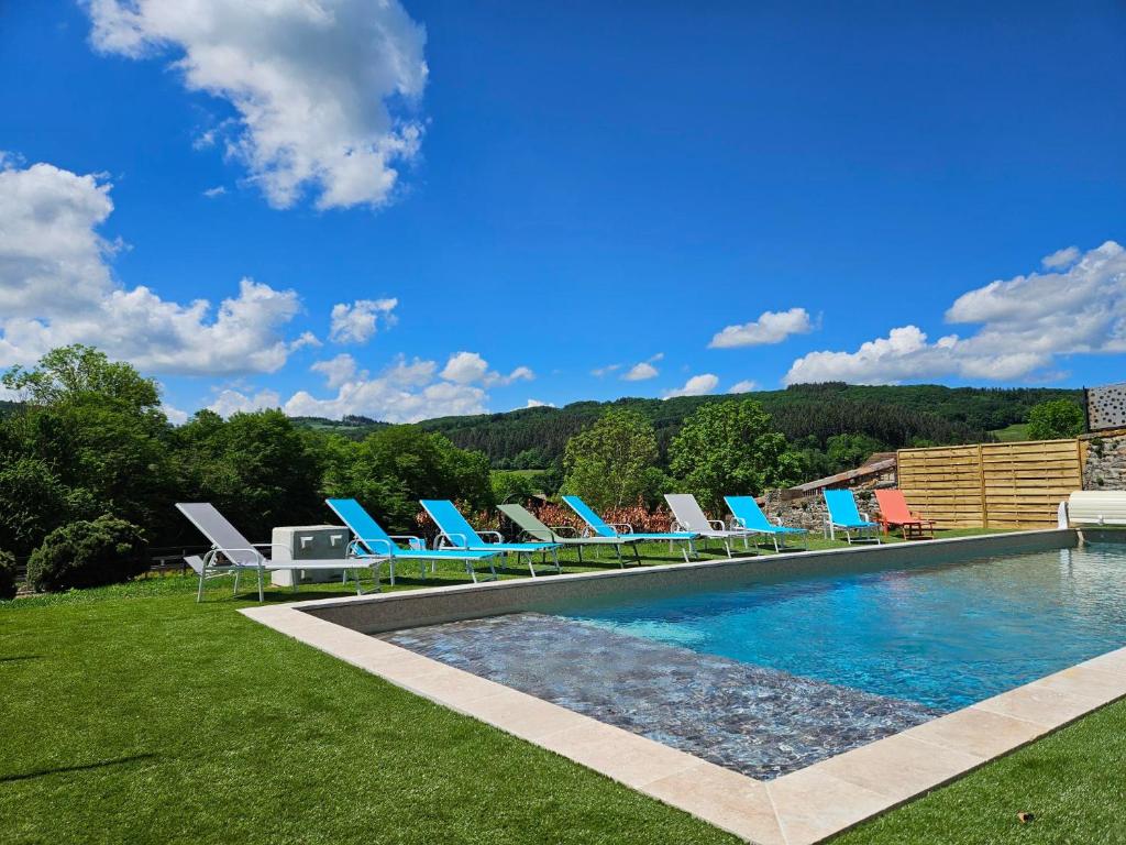 a group of chairs and a swimming pool at Gites de groupes Les Muriers in Bourgvilain