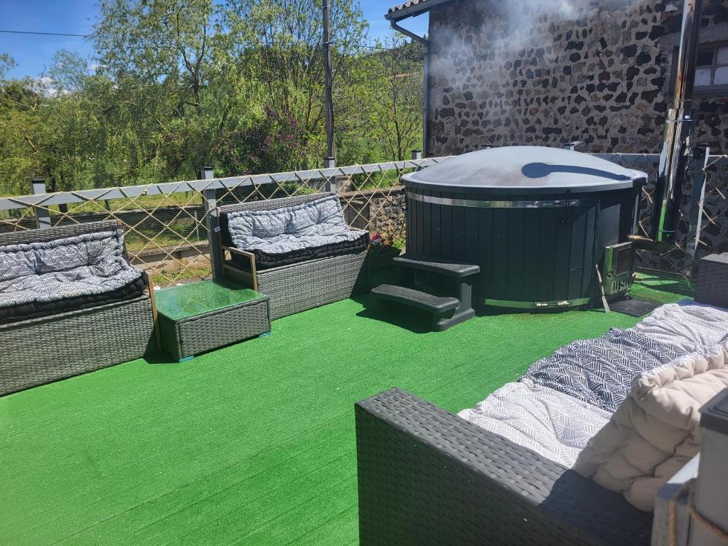 a garden with green grass and a hot tub at Maison d´hôtes La Dromandise in Saint-Arcons-de-Barges